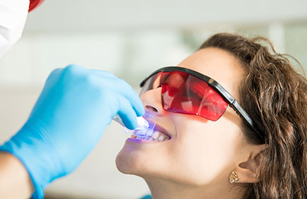 Dra Debora Reis – Clareamento Dental Aplicação de luz azul durante sessão de clareamento dental profissional em consultório